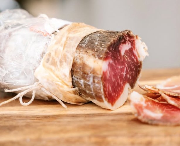 Coppa italienne entière, tranchée à la main sur planche en bois