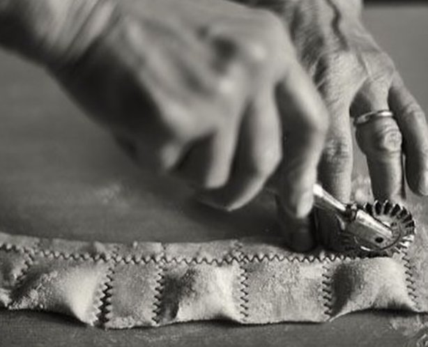 Mains d'artisan préparant des pâtes fraîches italiennes à la roulette dentelée