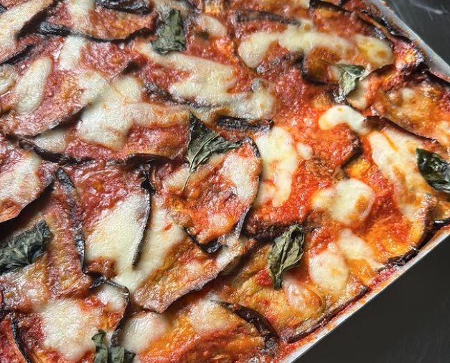 Pizza à la tranche garnie d'aubergines, mozzarella, basilic et tomate