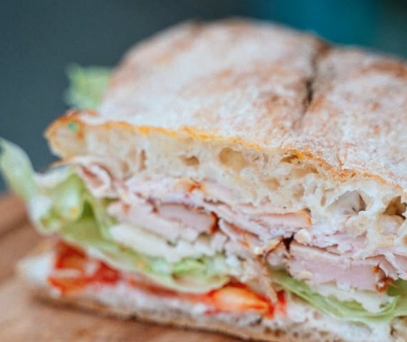 Sandwich focaccia garni de jambon, tomate, salade et fromage
